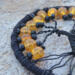 close up details of 8mm orange crackle glass beads adorn black wire tree of life